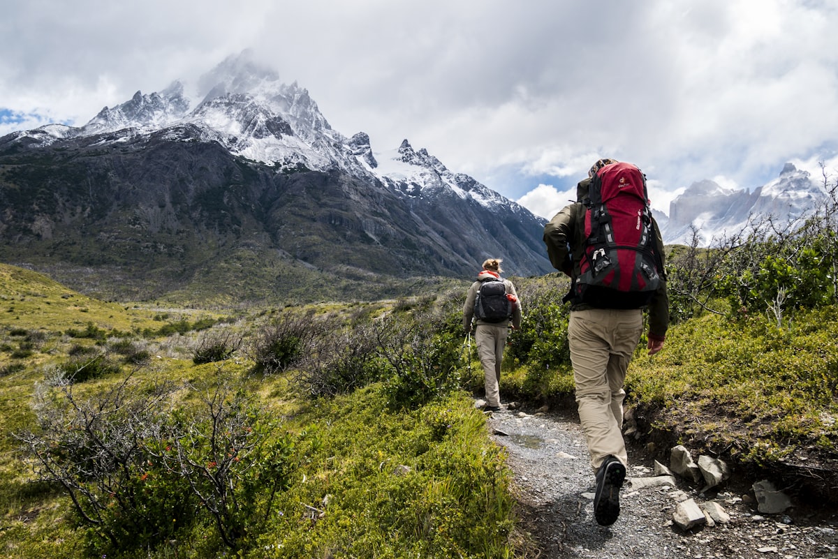 Hikers trekking a mountain trail toward snow-capped peaks, representing the winding path of an unconventional career